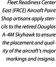 Fleet Readiness Center East (FRCE) Aircraft Paint Shop artisans apply stencils to the retired Douglas A 4M Skyhawk to...