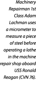 Machinery Repairman 1st Class Adam Lachman uses a micrometer to measure a piece of steel before operating a lathe in ...