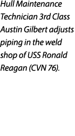 Hull Maintenance Technician 3rd Class Austin Gilbert adjusts piping in the weld shop of USS Ronald Reagan (CVN 76).