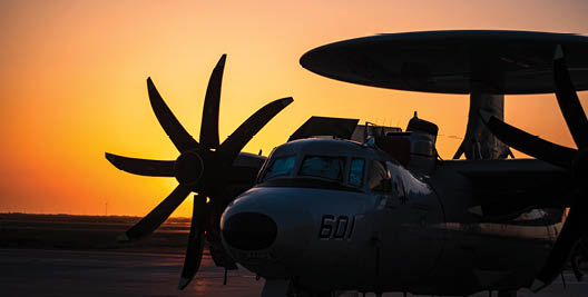 220505-N-KD414-0130 An An E-2D Advanced Hawkeye, assigned to the “Black Eagles” of Carrier Airborne Early Warning Squadron (VAW) 113, stands by during a sunset onboard Point Mugu Apr. 30, 2022. NBVC is comprised of three distinct facilities: Point Mugu, Port Hueneme, and San Nicolas Island. It is the largest employer in Ventura County and actively protects California’s largest coastal wetlands through its award-winning environmental programs.