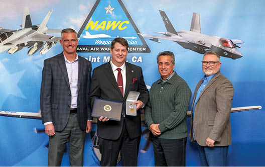 Clint Stammer (holding medal), F-35 Joint Program Office Electronic Attack & Countermeasures lead, poses with Pat Schuett (far left), Gerardo Garcia (second from right), and Tom Dowd (far right) following an award ceremony at Point Mugu, California, April 1. Stammer received the Office of the Secretary of Defense Exceptional Civilian Service medal, the highest honor awarded to career Department of Defense civilians. (U.S. Navy photo by Rob Grabendike)