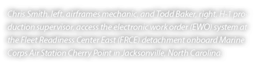 Chris Smith, left, airframes mechanic, and Todd Baker, right, H 1 production supervisor, access the electronic work o...