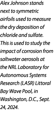 Alex Johnson stands next to symmetric airfoils used to measure the dry deposition of chloride and sulfate. This is us...
