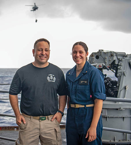 From left, Aviation Machinist's Mate Senior Chief Dan Reyes and his daughter, U.S. Midshipmen 2nd Class Gabriella Reyes, from Miami, Florida, pose for a photo during a vertical replenishment on the fantail aboard the aircraft carrier USS Nimitz (CVN 68) in the South China Sea, June 10, 2025. Nimitz is underway in the U.S. 7th Fleet area of operations on a scheduled deployment, demonstrating the U.S. Navy's unwavering commitment to a free and open Indo-Pacific. (U.S. Navy Photo by Mass Communication Specialist Seaman Apprentice Frankie M. Guage)