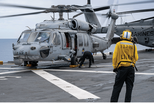 250707-N-WJ234-1058 CORAL SEA (July 7, 2025) Sailors chock and chain an MH-60S Seahawk from Helicopter Sea Combat Squadron (HSC) 25 to the flight deck of the forward-deployed amphibious assault ship USS America (LHA 6) while conducting flight operations in the Coral Sea, July 7. America, lead ship of the America Amphibious Ready Group, is operating in the U.S. 7th Fleet area of operations. U.S. 7th Fleet is the U.S. Navy’s largest forward-deployed numbered fleet, and routinely interacts and operates with allies and partners in preserving a free and open Indo-Pacific region. (U.S. Navy photo by Mass Communication Specialist Seaman Sam McNeely)