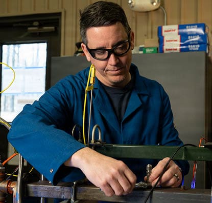 Brian Fisher, Ph.D., U.S. Naval Research Laboratory mechanical engineer, adjusts fittings on an optically-accessible solid-fuel slab burner at NRL’s Combustion Lab in Chesapeake Beach, Maryland, Jan. 15, 2026. Researchers and engineers at NRL use an optically-accessible solid-fuel slab burner to perform combustion experiments at conditions relevant to solid-fuel ramjet flight. (U.S. Navy photo by Jonathan Sunderman)