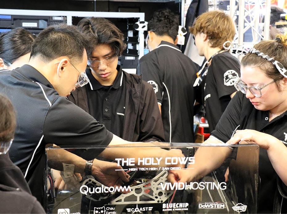 Members of The Holy Cows, a FIRST Robotics Competition team from High Tech High in San Diego, work on their robot in the pit area during the California District Hueneme Port Event at the Port of Hueneme, Calif., March 8. 