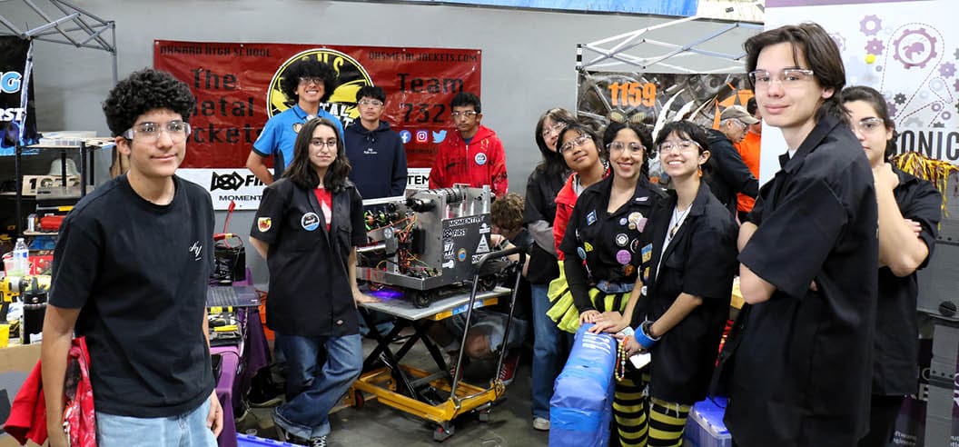 Members of Team 7327, the Metal Jackets from Oxnard High School, pose with their robot in the pit area during the California District Hueneme Port Event at FATHOMWERX in Port Hueneme, Calif., March 8. 