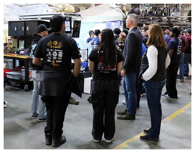 Patrick Schuett, director of Air Wing Integration and Interoperability/Electronic Warfare Effects at Naval Air Warfare Center Weapons Division, visits the pit area of NAWCWD-sponsored Team 4711, the Flying Aces, from ACE Charter High School in Camarillo, during the California District Hueneme Port Event at FATHOMWERX in Port Hueneme, Calif., March 8.