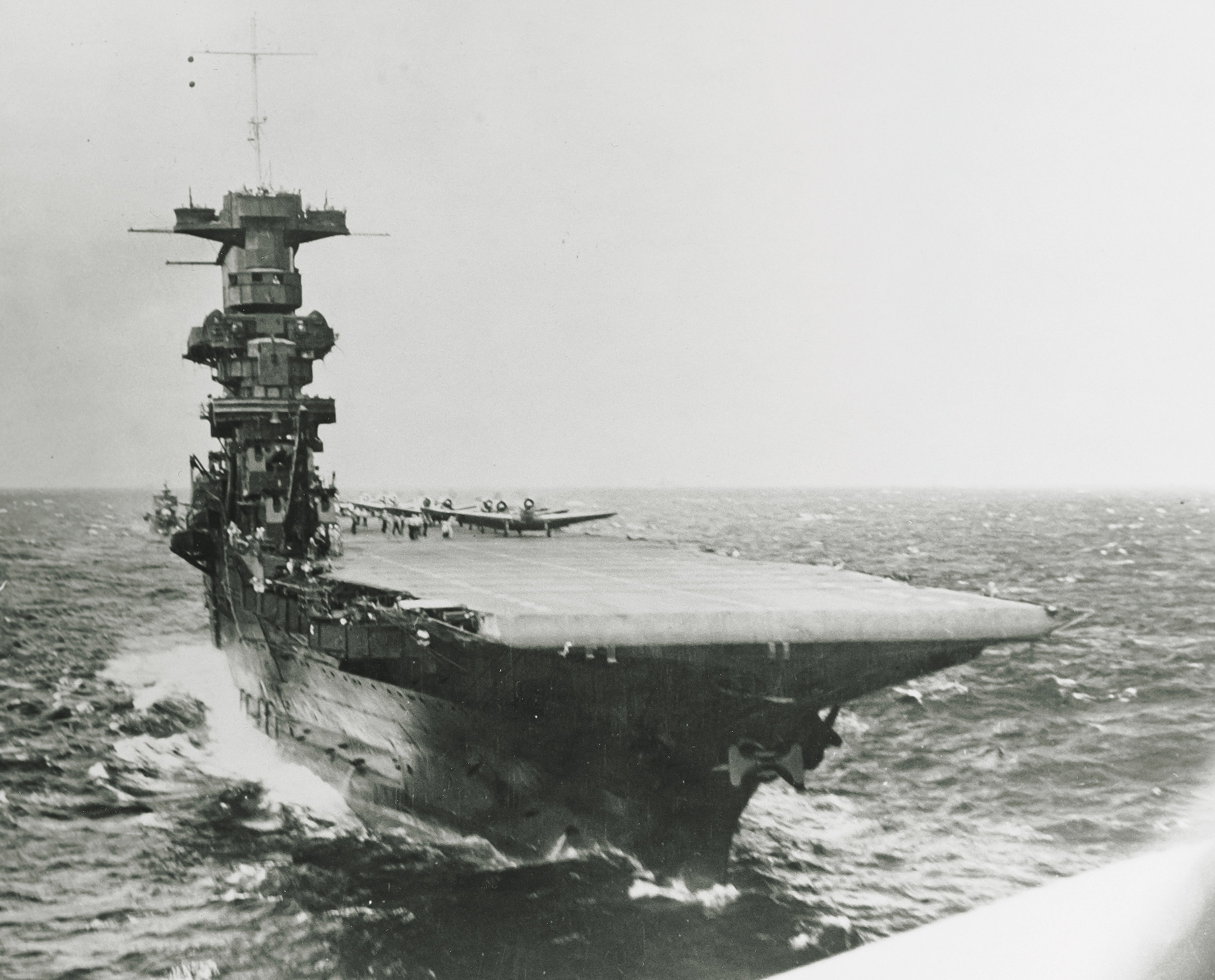 USS Saratoga (CV 3) launching planes, circa summer 1941, as seen from the rear cockpit of a plane that has just taken off.